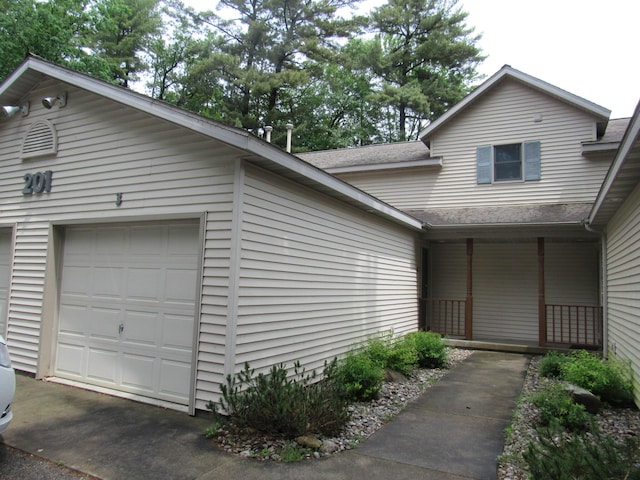 201 White Deer Trl, Prudenville, MI 48651 - view of front facade with a garage, roof with shingles, and covered porch