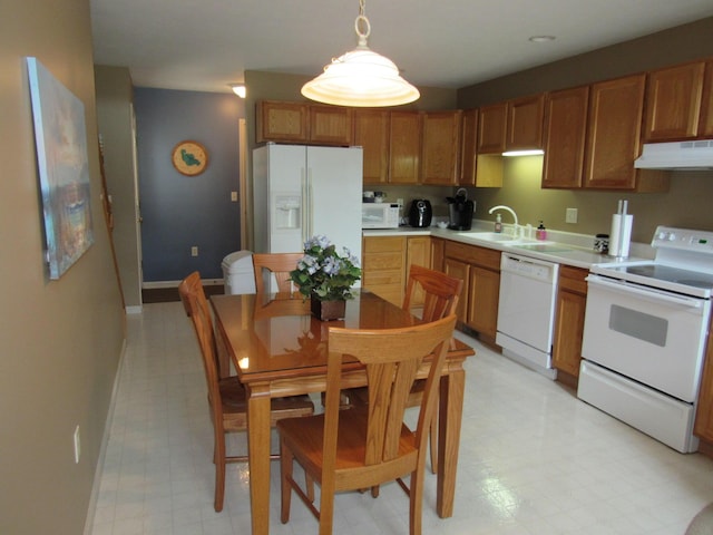201 White Deer Trl, Prudenville, MI 48651 - kitchen with white appliances, under cabinet range hood, light countertops, hanging light fixtures, and light flooring
