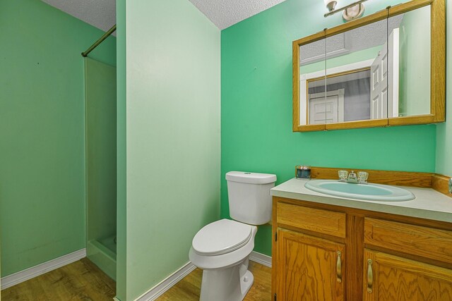1655 Arrowhead Trl, West Branch, MI 48661 - full bathroom with a textured ceiling, vanity, wood finished floors, and a shower