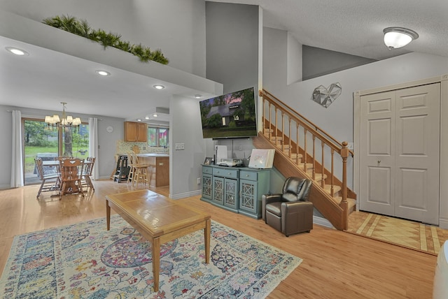 1655 Arrowhead Trl, West Branch, MI 48661 - living area with stairway, a chandelier, light wood-style flooring, recessed lighting, and high vaulted ceiling