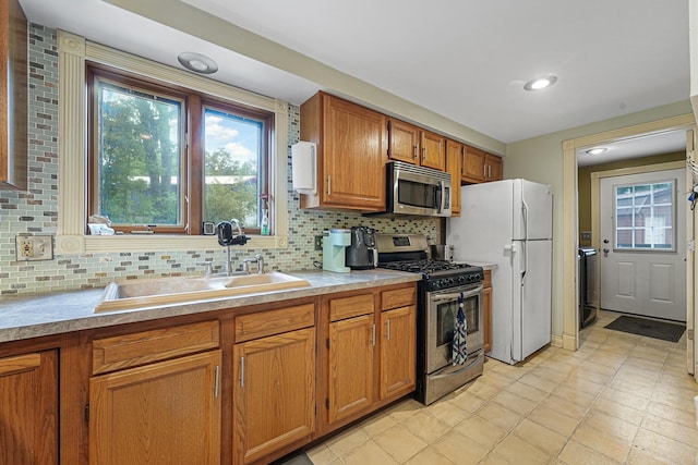 1655 Arrowhead Trl, West Branch, MI 48661 - kitchen with stainless steel appliances, brown cabinetry, decorative backsplash, and recessed lighting