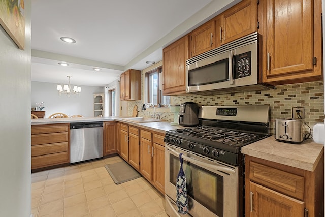 1655 Arrowhead Trl, West Branch, MI 48661 - kitchen with stainless steel appliances, light countertops, a chandelier, brown cabinetry, and recessed lighting