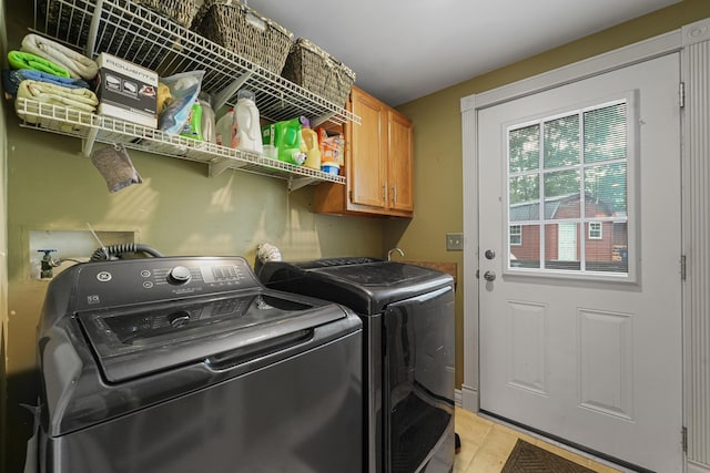 1655 Arrowhead Trl, West Branch, MI 48661 - laundry area featuring washer and clothes dryer, cabinet space, and light tile patterned flooring