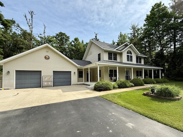 2176 Deepwoods Dr, Gaylord, MI 49735 - view of front of home featuring driveway, a porch, a front lawn, a garage, and roof with shingles