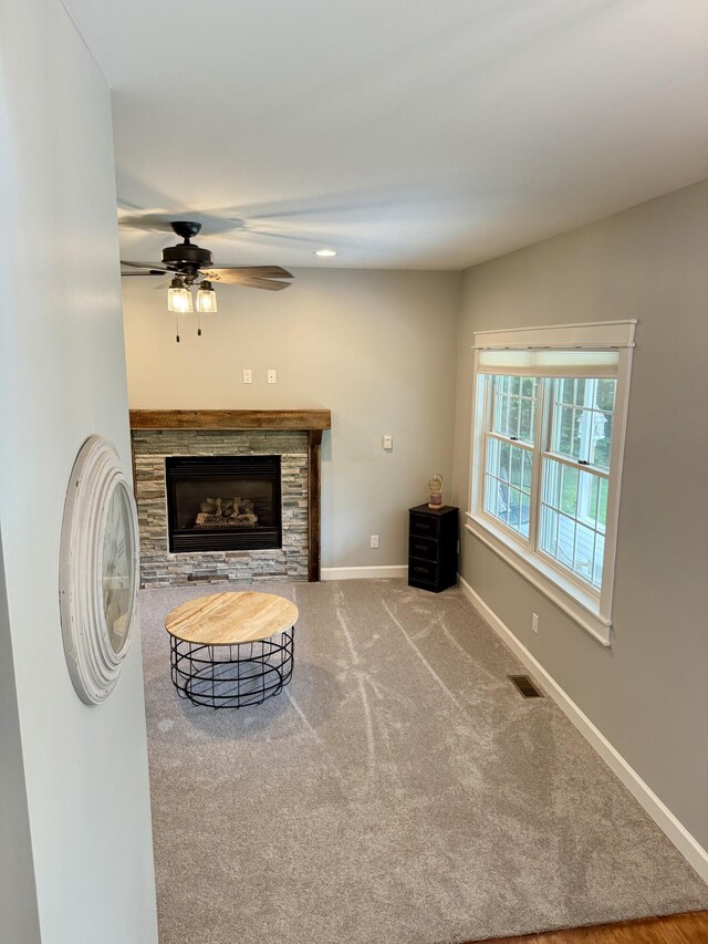 2176 Deepwoods Dr, Gaylord, MI 49735 - living room featuring a ceiling fan, carpet floors, and a stone fireplace