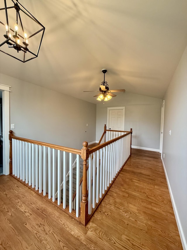 2176 Deepwoods Dr, Gaylord, MI 49735 - staircase featuring wood finished floors, vaulted ceiling, a chandelier, and ceiling fan