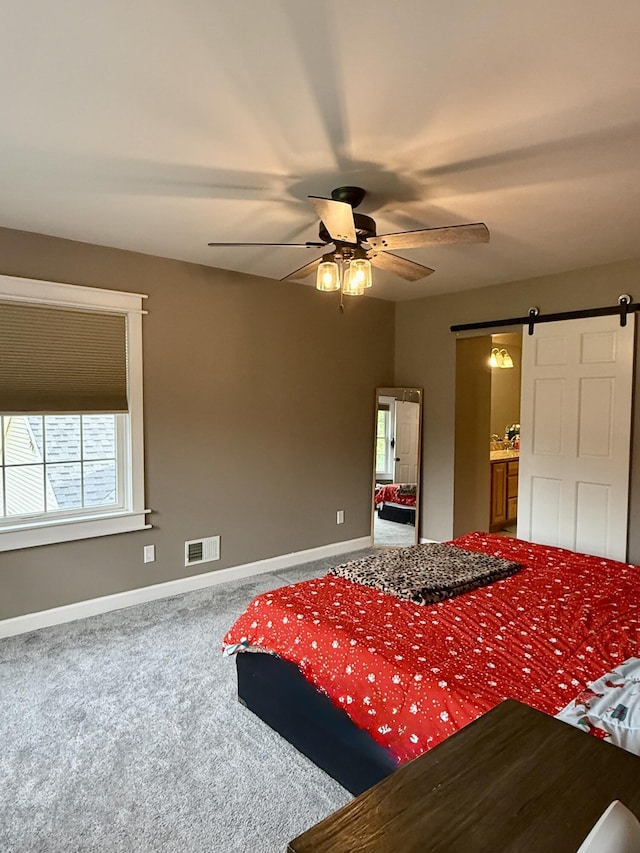 2176 Deepwoods Dr, Gaylord, MI 49735 - carpeted bedroom with a barn door and a ceiling fan