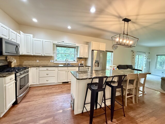2176 Deepwoods Dr, Gaylord, MI 49735 - kitchen featuring appliances with stainless steel finishes, a breakfast bar, a center island, open floor plan, and tasteful backsplash