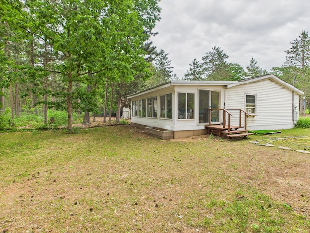2651 Chipmunk Trl, Grayling, MI 49738 - back of house featuring a sunroom and a lawn