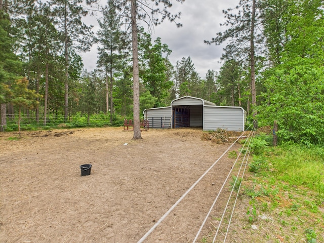 2651 Chipmunk Trl, Grayling, MI 49738 - view of yard featuring a carport, dirt driveway, and an outbuilding