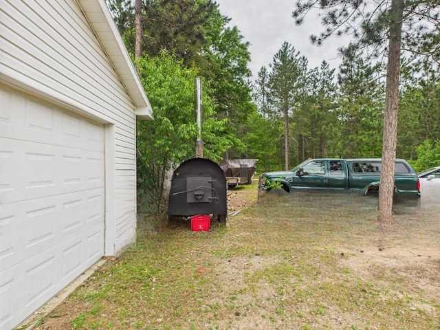 2651 Chipmunk Trl, Grayling, MI 49738 - view of yard featuring a garage and view of wooded area