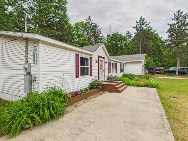 2651 Chipmunk Trl, Grayling, MI 49738 - view of front of home featuring a front yard, roof with shingles, and view of wooded area