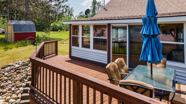 1960 Highbank Trl, Lewiston, MI 49756 - wooden terrace with a storage unit, outdoor dining space, a yard, and a sunroom