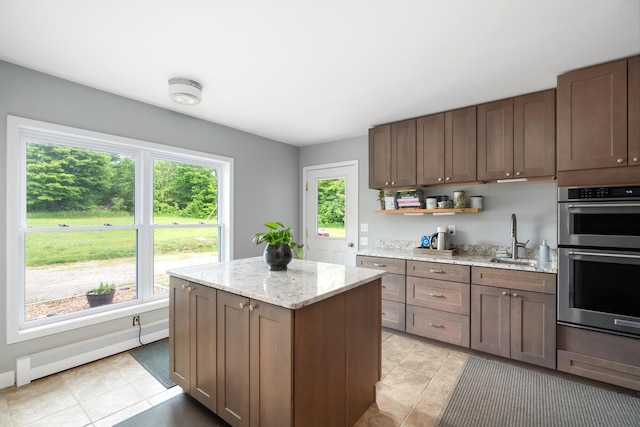 9660 Richardson Rd, Cheboygan, MI 49721 - kitchen with stainless steel double oven, a kitchen island, open shelves, light tile patterned floors, and light stone counters