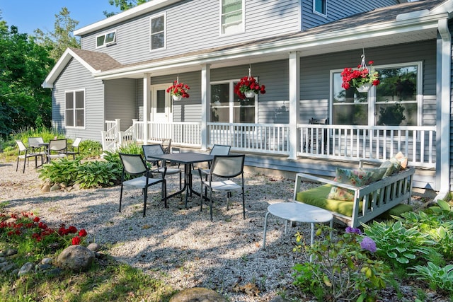 9660 Richardson Rd, Cheboygan, MI 49721 - rear view of property with a porch, roof with shingles, and outdoor dining space