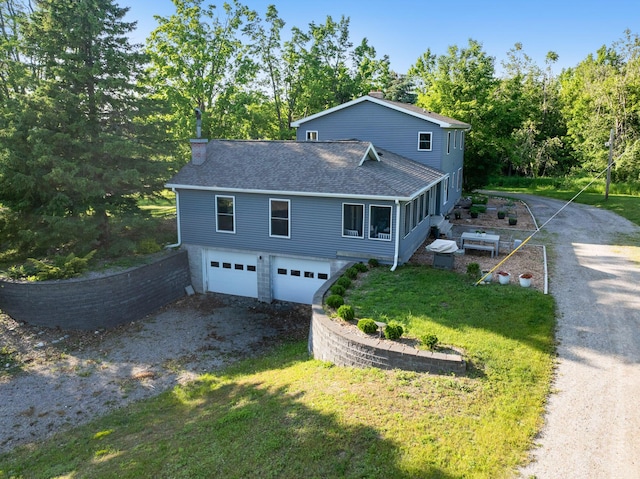 9660 Richardson Rd, Cheboygan, MI 49721 - view of front of home with dirt driveway, a garage, a shingled roof, and a chimney