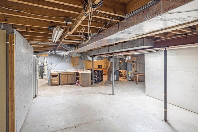 6304 Old 27, Vanderbilt, MI 49795 - unfinished below grade area with gas water heater and freestanding refrigerator