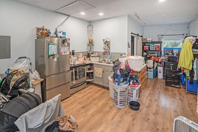 6304 Old 27, Vanderbilt, MI 49795 - kitchen with stainless steel appliances, light wood-style flooring, electric panel, recessed lighting, and a barn door