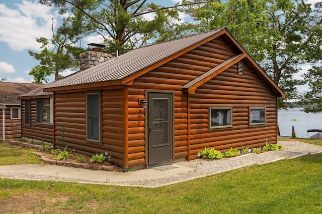 2061 Dreamers Ln, Lewiston, MI 49756 - rear view of house with a chimney, faux log siding, a metal roof, and a lawn