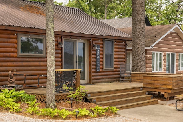 2061 Dreamers Ln, Lewiston, MI 49756 - view of exterior entry featuring a deck, a metal roof, and a shingled roof