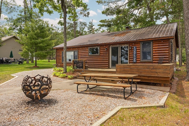 2061 Dreamers Ln, Lewiston, MI 49756 - rear view of house featuring a fire pit, a metal roof, a patio area, and a wooden deck