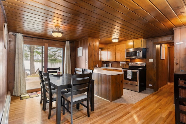 2061 Dreamers Ln, Lewiston, MI 49756 - dining area with a baseboard radiator, wood ceiling, wooden walls, light wood finished floors, and a water view