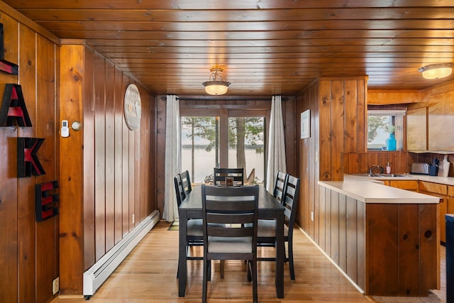2061 Dreamers Ln, Lewiston, MI 49756 - dining space with a baseboard heating unit, wooden ceiling, light wood-style floors, and wooden walls