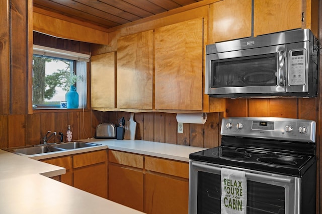 2061 Dreamers Ln, Lewiston, MI 49756 - kitchen with stainless steel appliances, wood ceiling, light countertops, and wooden walls