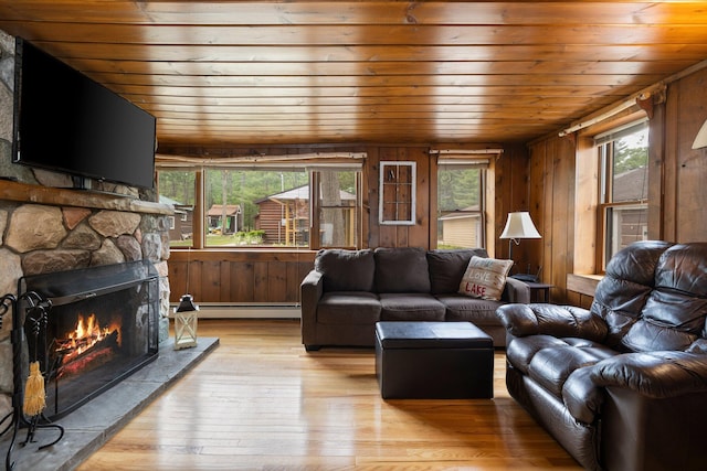2061 Dreamers Ln, Lewiston, MI 49756 - living room featuring wooden ceiling, light wood-style flooring, wooden walls, a fireplace, and a baseboard heating unit