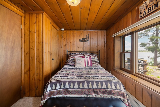 2061 Dreamers Ln, Lewiston, MI 49756 - carpeted bedroom featuring wooden ceiling, multiple windows, wooden walls, and a baseboard radiator