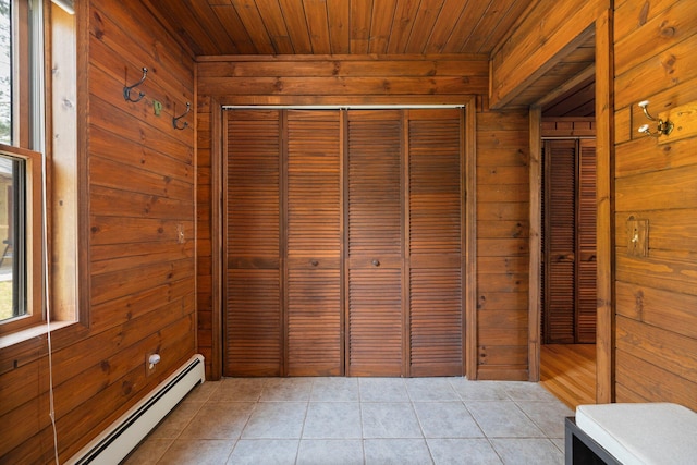 2061 Dreamers Ln, Lewiston, MI 49756 - unfurnished bedroom with wood walls, baseboard heating, light tile patterned floors, wood ceiling, and a closet