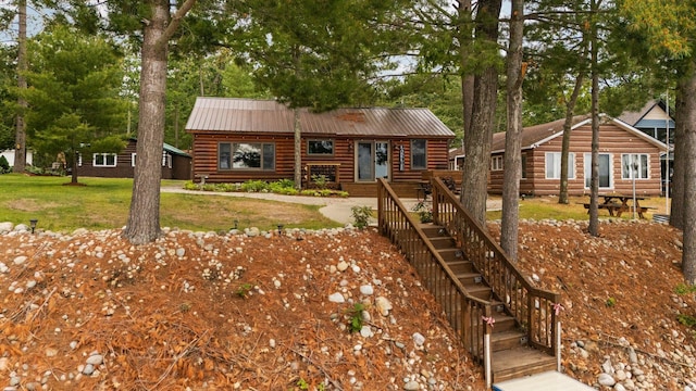 2061 Dreamers Ln, Lewiston, MI 49756 - log cabin featuring a metal roof, log siding, and a front lawn