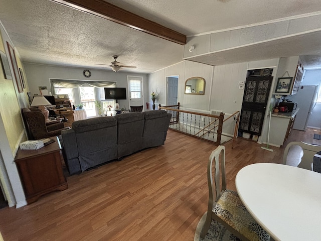 10604 Adams St, Ossineke, MI 49766 - living area featuring wood finished floors, ceiling fan, beam ceiling, and a textured ceiling