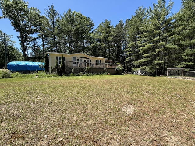 10604 Adams St, Ossineke, MI 49766 - view of front facade with a wooden deck and a front yard