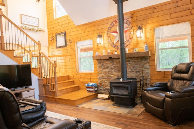 4696 Glacial Field Dr, Elmira, MI 49730 - living room with wood walls, a wood stove, wood finished floors, and stairway