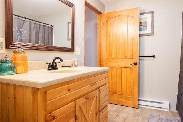 4696 Glacial Field Dr, Elmira, MI 49730 - bathroom featuring a baseboard heating unit, vanity, and wood finished floors