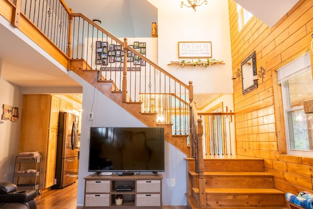 4696 Glacial Field Dr, Elmira, MI 49730 - stairway with wood walls, a towering ceiling, and wood finished floors