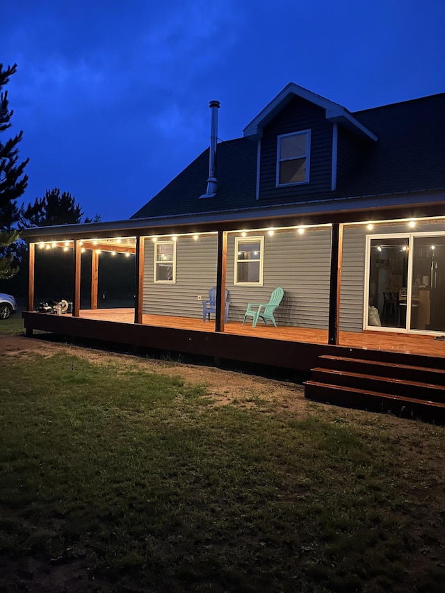 4696 Glacial Field Dr, Elmira, MI 49730 - back of house at night with a yard and a wooden deck