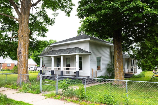 210 N Maple St, Mancelona, MI 49659 - view of front of property with a porch, a gate, a fenced front yard, and a shingled roof