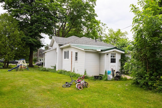 210 N Maple St, Mancelona, MI 49659 - back of property featuring a yard and roof with shingles