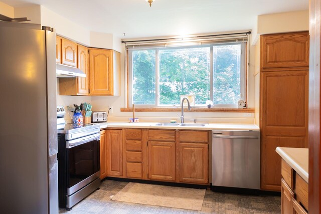 210 N Maple St, Mancelona, MI 49659 - kitchen featuring appliances with stainless steel finishes, under cabinet range hood, and light countertops