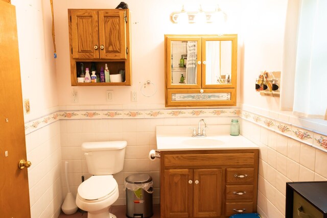 210 N Maple St, Mancelona, MI 49659 - bathroom with vanity, a wainscoted wall, and tile walls