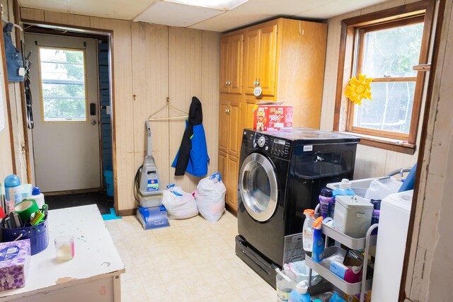 210 N Maple St, Mancelona, MI 49659 - laundry area featuring washing machine and clothes dryer, cabinet space, light flooring, and wood walls