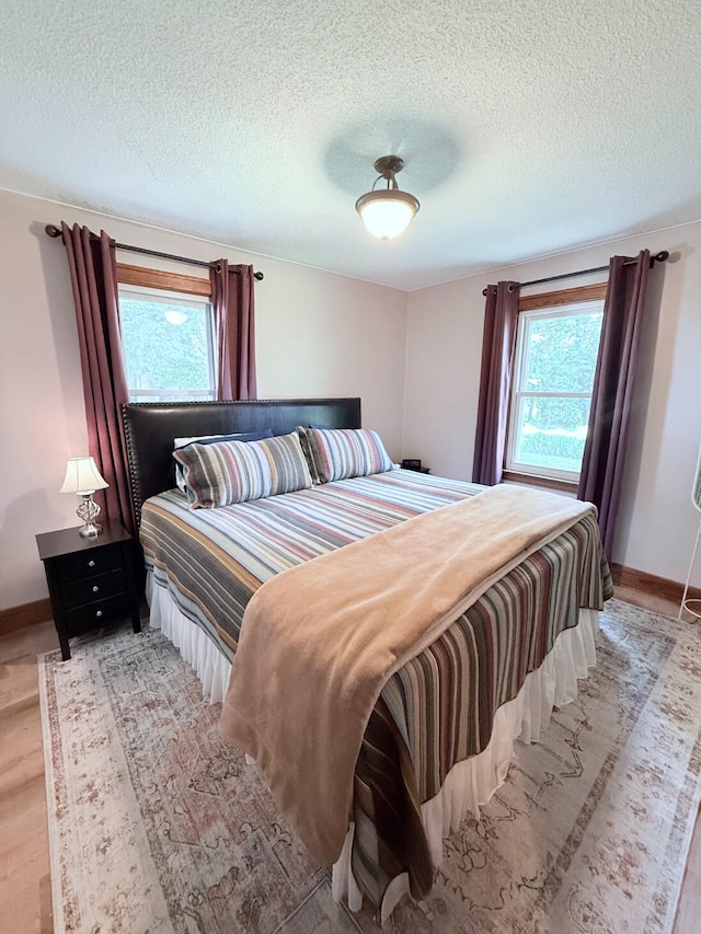 3628 Rau Rd, West Branch, MI 48661 - bedroom with light wood-type flooring and a textured ceiling