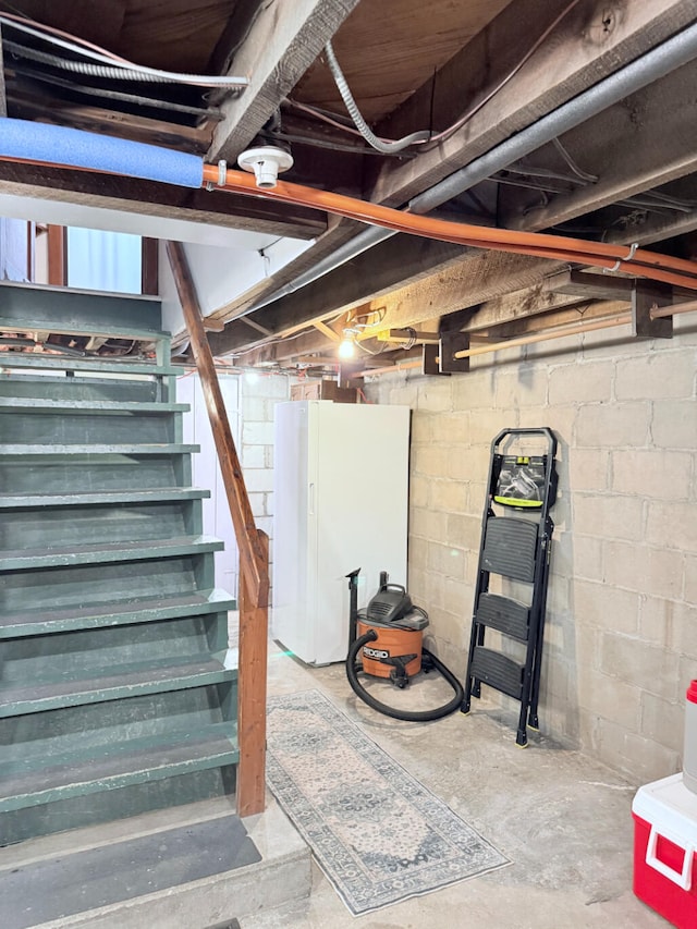 3628 Rau Rd, West Branch, MI 48661 - unfinished below grade area featuring stairs and freestanding refrigerator