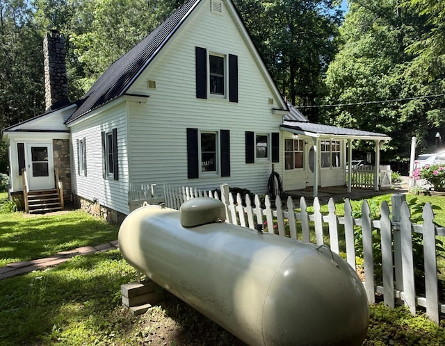 3628 Rau Rd, West Branch, MI 48661 - rear view of property with a chimney, a metal roof, and a yard