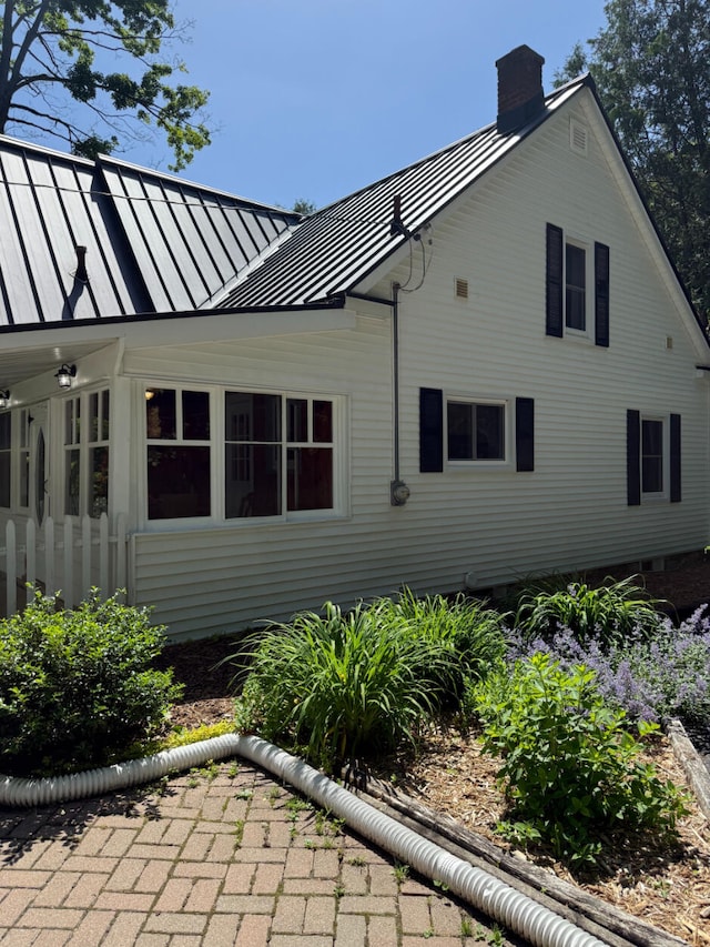 3628 Rau Rd, West Branch, MI 48661 - view of property exterior with a standing seam roof, a chimney, and a metal roof