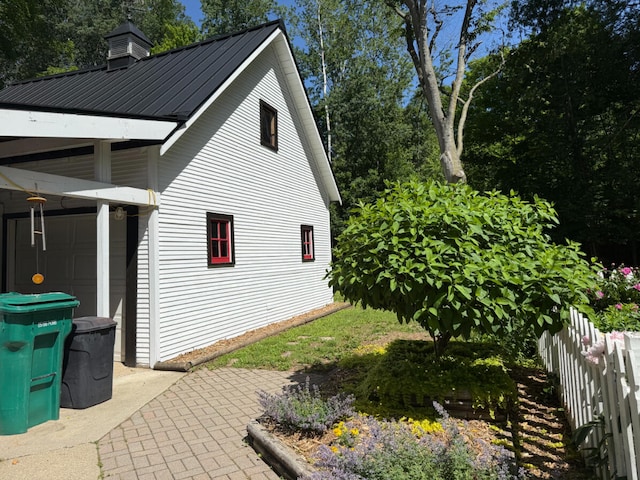3628 Rau Rd, West Branch, MI 48661 - view of home's exterior with a metal roof, a patio, and a chimney