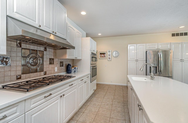 118 Frisco Dr, Houghton Lake, MI 48629 - kitchen with stainless steel appliances, light tile patterned floors, tasteful backsplash, light countertops, and under cabinet range hood
