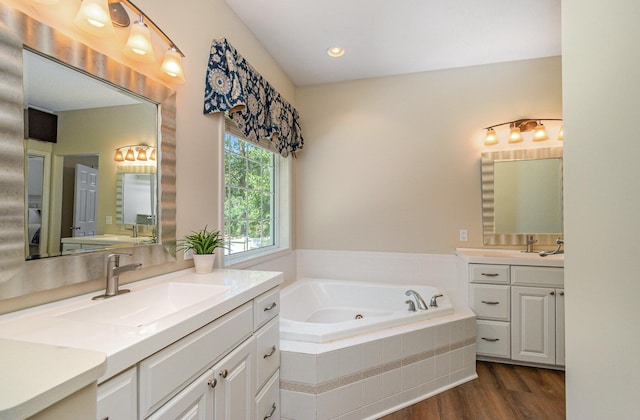 118 Frisco Dr, Houghton Lake, MI 48629 - bathroom featuring two vanities, a bath, wood finished floors, and recessed lighting